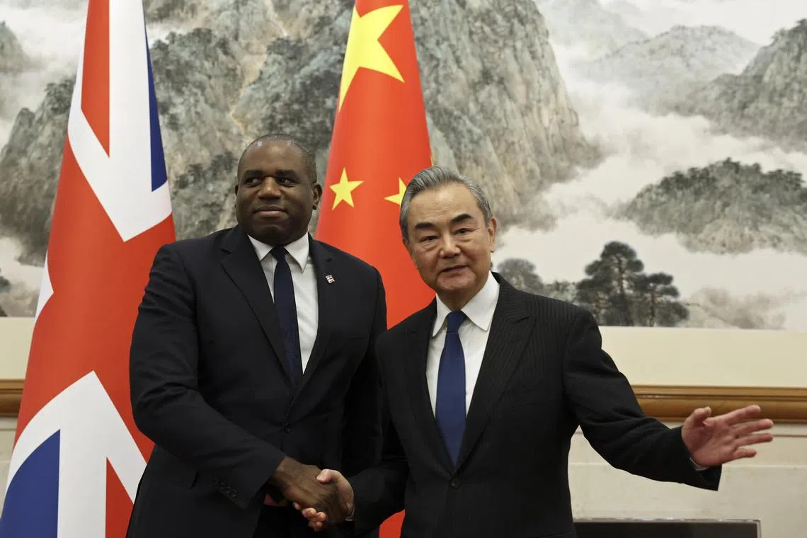 epa11666149 Britain's Foreign Secretary David Lammy and Chinese Foreign Minister Wang Yi shake hands before their meeting at the Diaoyutai State Guesthouse in Beijing, China, 18 October 2024.  EPA-EFE/FLORENCE LO / POOL