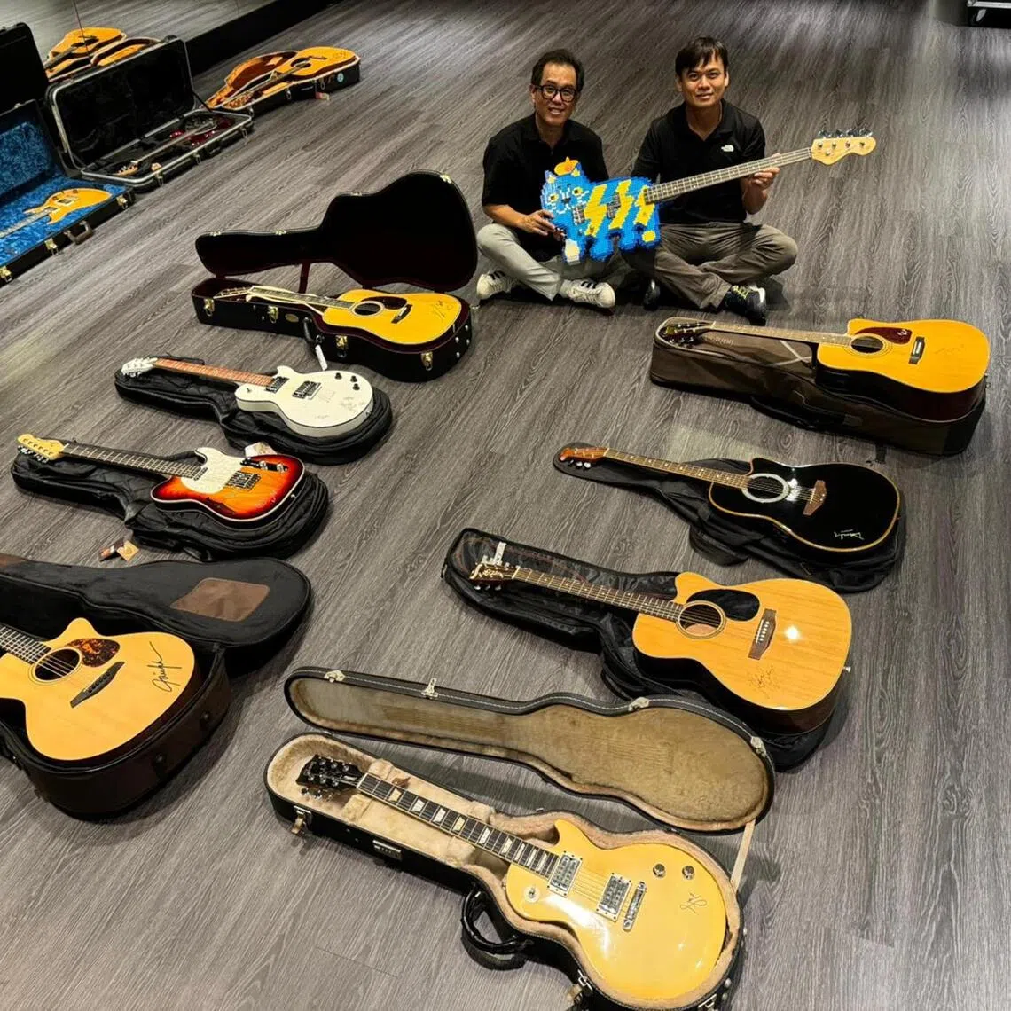 The Music Society, Singapore (SGMUSO) chairman and Timbre Group CEO Danny Loong (left) and SGMUSO vice chairman and The Ebenex Group CEO David Ebenezer Toh with some of the guitars that will be auctioned off for the Gift a Guitar charity initiative.
