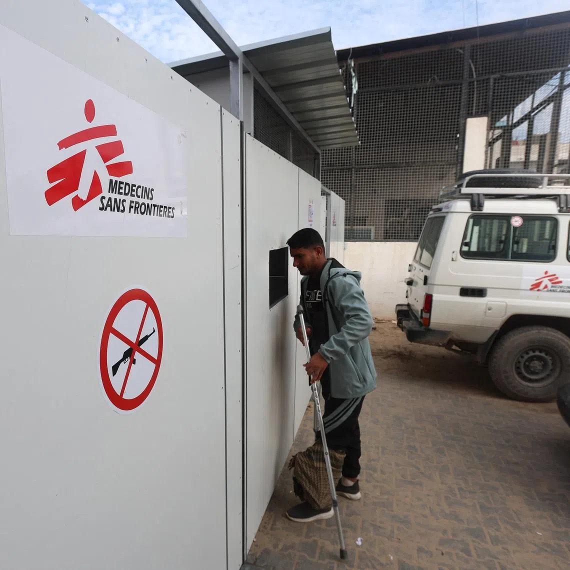 A Palestinian war-wounded man waits at the entrance, hoping to receive medical treatment, at a clinic run by medical charity Medecins Sans Frontieres (MSF), amid shortages of medical supplies, in Khan Younis, southern Gaza Strip, December 31, 2025. REUTERS/Ramadan Abed