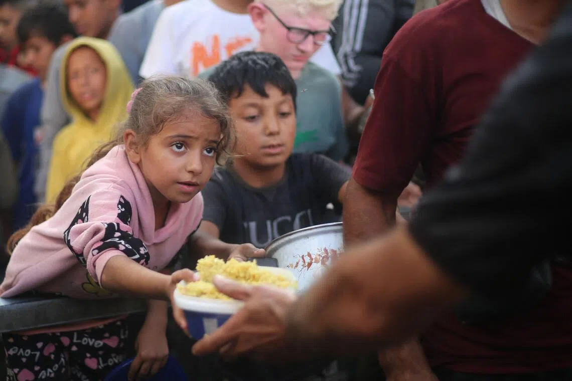 Palestinians at a charity kitchen in the Nuseirat refugee camp, in the central Gaza Strip, on Oct 21.