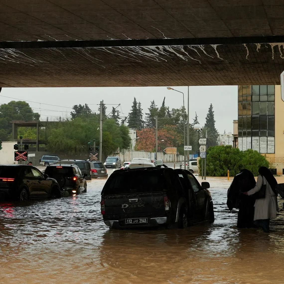 People and vehicles attempt to travel through flooded streets as torrential rains hit the country, in Tunis, Tunisia January 20, 2026. REUTERS/Jihed Abidellaoui