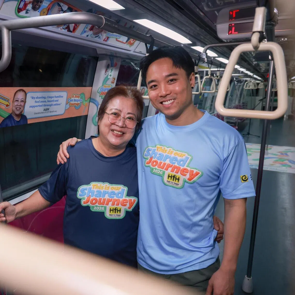ST20260504_202669000114/johair04/Justine Ong/Jason Quah

Judy Tan, grandmother of a Children's Cancer Foundation (CCF) beneficiary, and her son Eugene Tay, uncle of beneficiary, pictured onboard a Hair for Hope 2026 Concept Train on May 4, 2026. CCF, in collaboration with SMRT Trains, launches the Hair for Hope 2026 Concept Train, bringing the campaign's message of solidarity and support directly into the daily journeys of commuters across Singapore. ST PHOTO: JASON QUAH