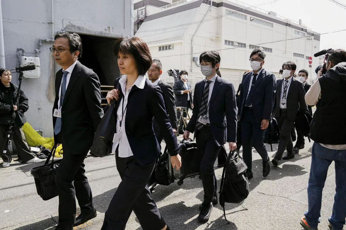 Japanese health ministry officials heading to search a Kobayashi Pharmaceutical factory in Osaka on March 30.
