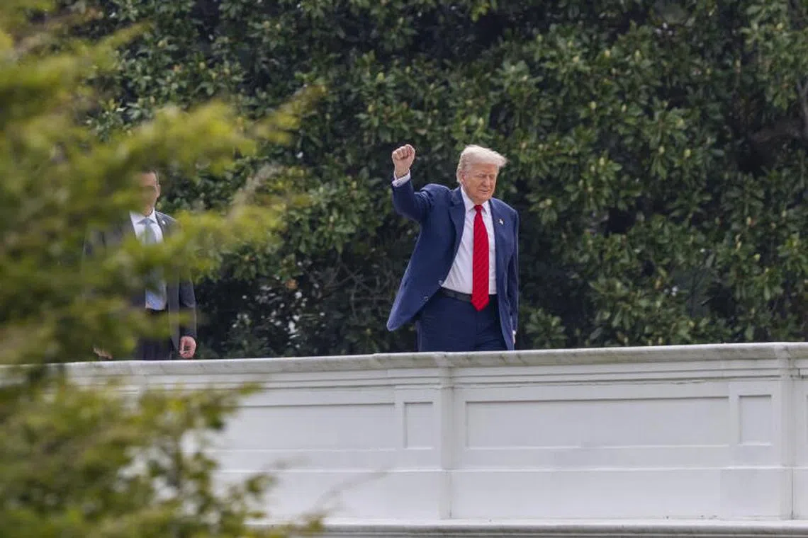 US President Donald Trump responds to a question from the news media as he tours the roof at the White House.