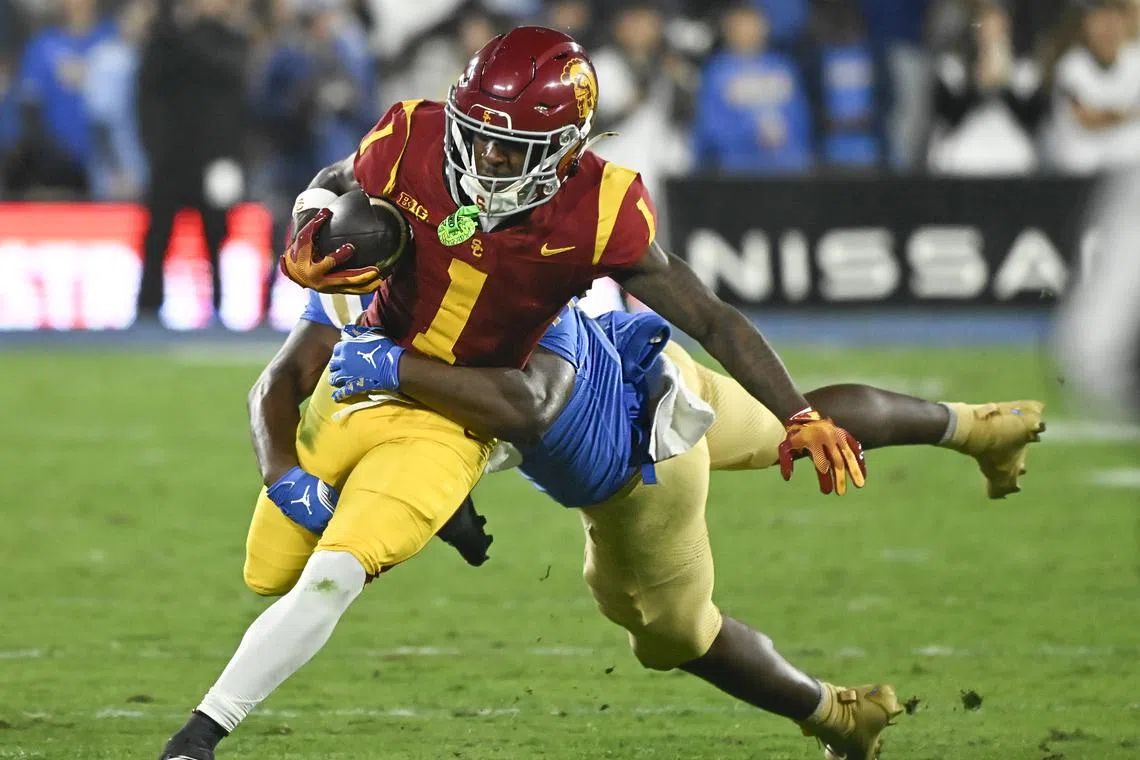 Nov 23, 2024; Pasadena, California, USA; USC Trojans wide receiver Zachariah Branch (1) is tackled by UCLA Bruins linebacker Jalen Woods (17) during the second quarter at Rose Bowl. Robert Hanashiro-Imagn Images/File Photo