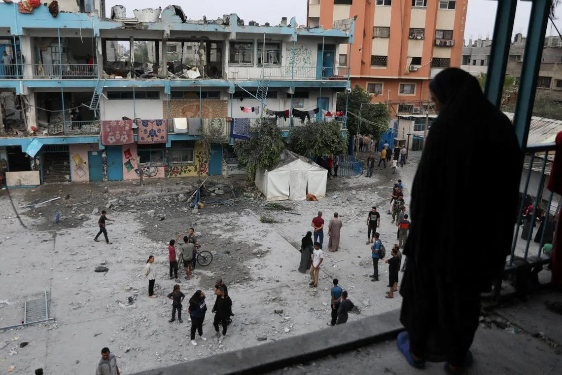 Palestinians inspecting the site of an Israeli strike on a UNRWA school sheltering displaced people, in a refugee camp in the central Gaza Strip, on June 6.