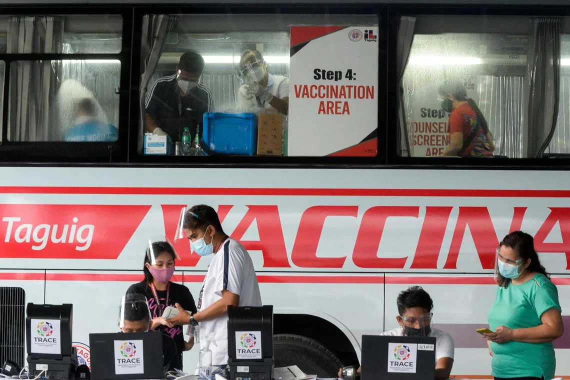 FILE PHOTO: Health workers encode information and prepare vaccines against the coronavirus (COVID-19) at a mobile vaccination site in Taguig, Metro Manila, Philippines, May 21, 2021. REUTERS/Lisa Marie David/File Photo