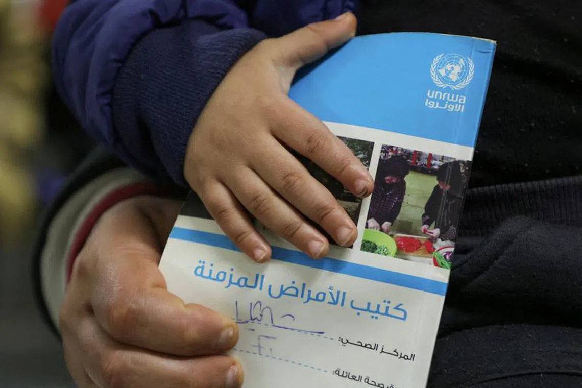 FILE PHOTO: A child holds a booklet as he waits inside a United Nations Relief and Works Agency (UNRWA) health center at Shatila Palestinian refugee camp, in Beirut suburbs, Lebanon January 30, 2024. REUTERS/Mohamed Azakir