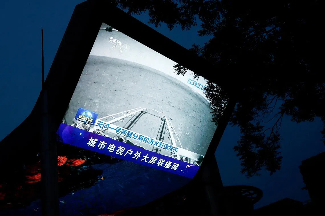 FILE PHOTO: A screen broadcasts a CCTV state media news bulletin, showing an image of Mars taken by Chinese Mars rover Zhurong as part of the Tianwen-1 mission, in Beijing, China, May 19, 2021. REUTERS/Thomas Peter/File Photo