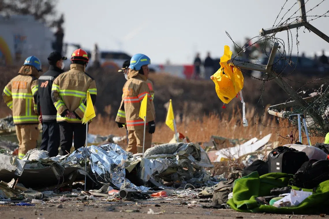 A life jacket hangs on fencing next to the wreckage of an aircraft that crashed after it went off the runway at Muan International Airport, in Muan, South Korea, December 29, 2024. REUTERS/Kim Hong-Ji