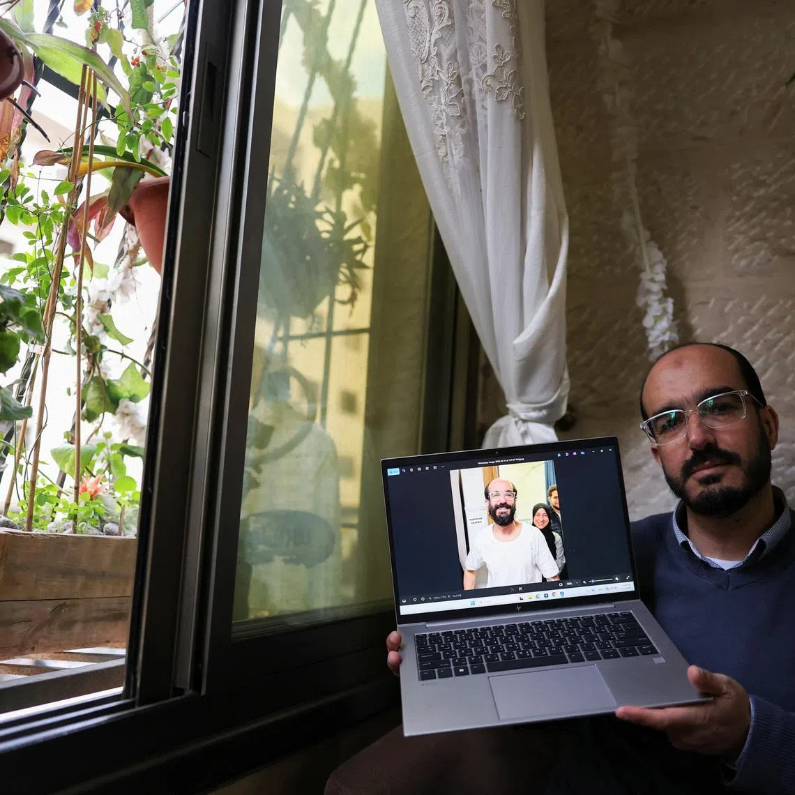 Samer Khaweireh, 45, shows a photo of how he appeared the day he was released from prison four weeks ago after he said he lost 22 kilos of weight in nine months, as he sits in his home in Nablus in the Israeli-occupied West Bank, February 11, 2026.REUTERS/Ammar Awad