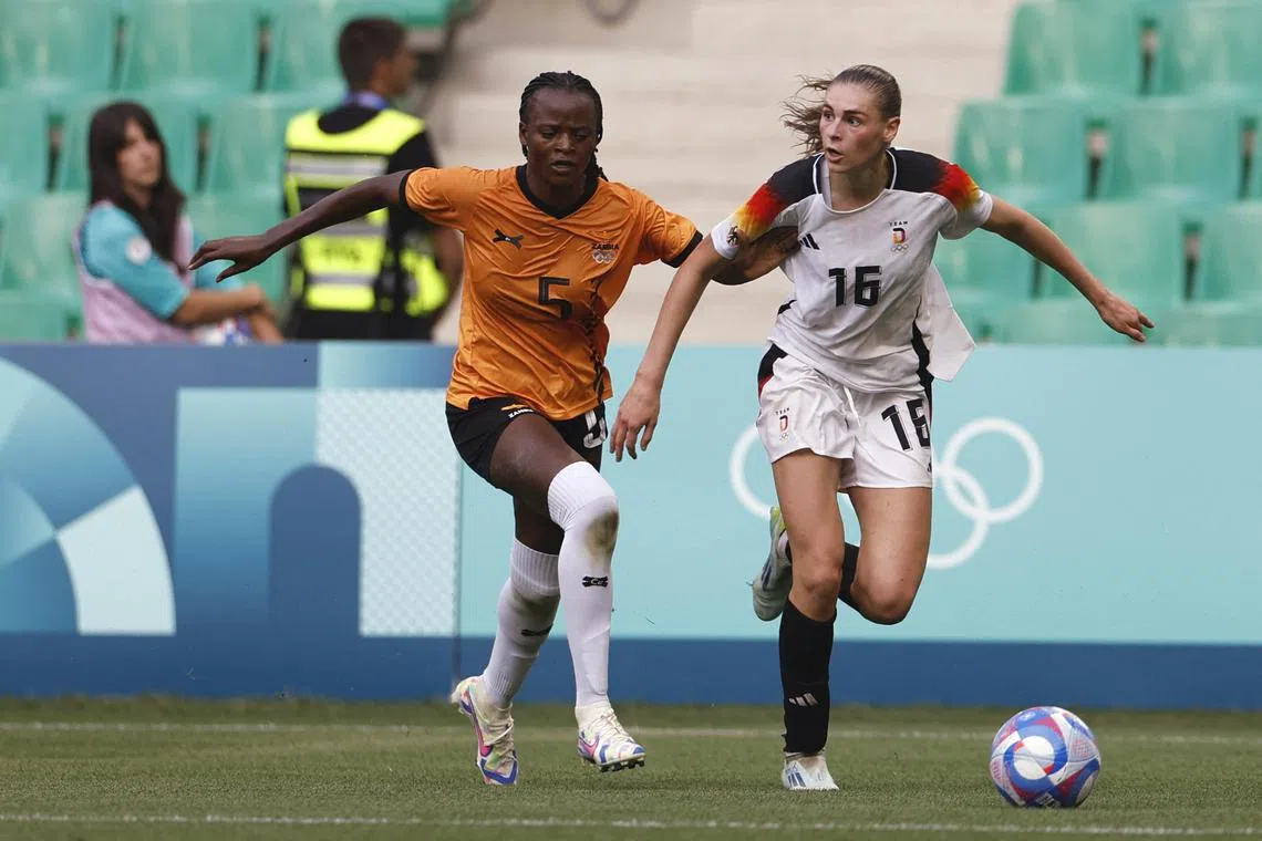 Paris 2024 Olympics - Football - Women's Group B - Zambia vs Germany - Geoffroy-Guichard Stadium, Saint-Etienne, France - July 31, 2024. Jule Brand of Germany in action with Pauline Zulu of Zambia. REUTERS/Thaier Al-Sudani