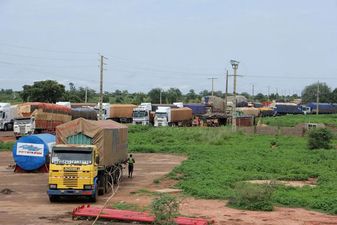 FILE PHOTO: Trucks carrying food, humanitarian aid, and industrial equipment wait due to sanctions imposed by Niger's regional and international allies, in the border town of Malanville, Benin August 18, 2023. REUTERS/Coffi Seraphin Zounyekpe/File Photo