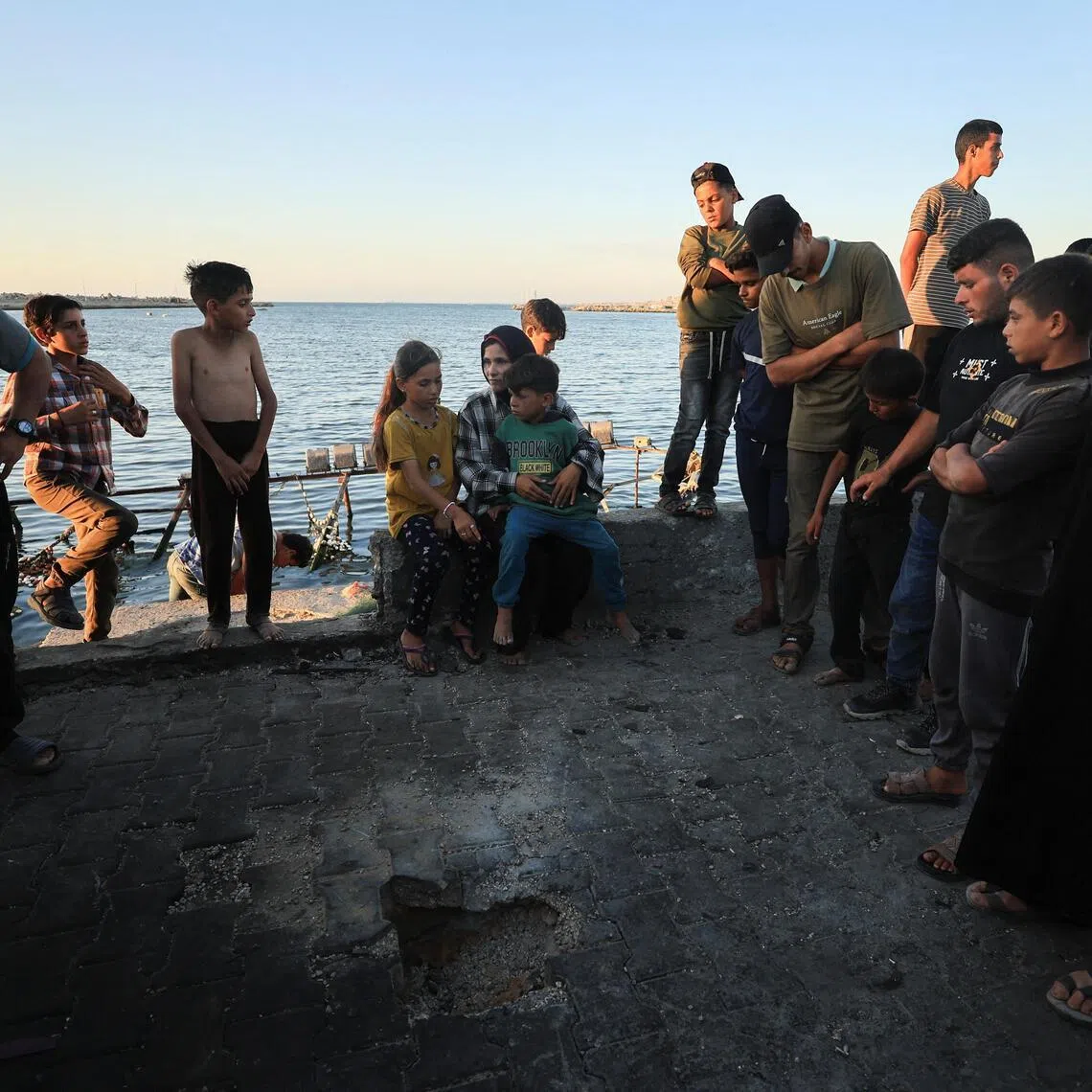 Palestinians gathering at the site of a May 31 Israeli air strike on a cafe in Gaza City's seaport.