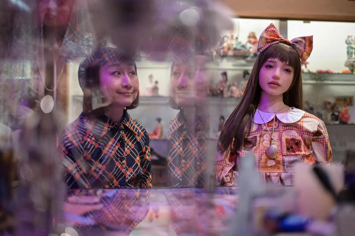 TOPSHOT - This photo taken on February 10, 2025 shows Beniko (L), a former brothel prostitute-turned professional photographer, posing next to a silicon doll seated at the in-house bar, following an interview with AFP at the "Museum of Roadside Art" in the area of Mukojima in the Sumida ward of Tokyo. The 52-year-old photographer from Saitama, a suburb of Tokyo, spent a decade working as a prostitute in the red-light district of Yoshiwara before making Japan's pleasure districts her preferred subject. (Photo by Richard A. Brooks / AFP) / TO GO WITH STORY: Japan-history-culture-socia-lphotography-women, FEATURE by Caroline GARDIN