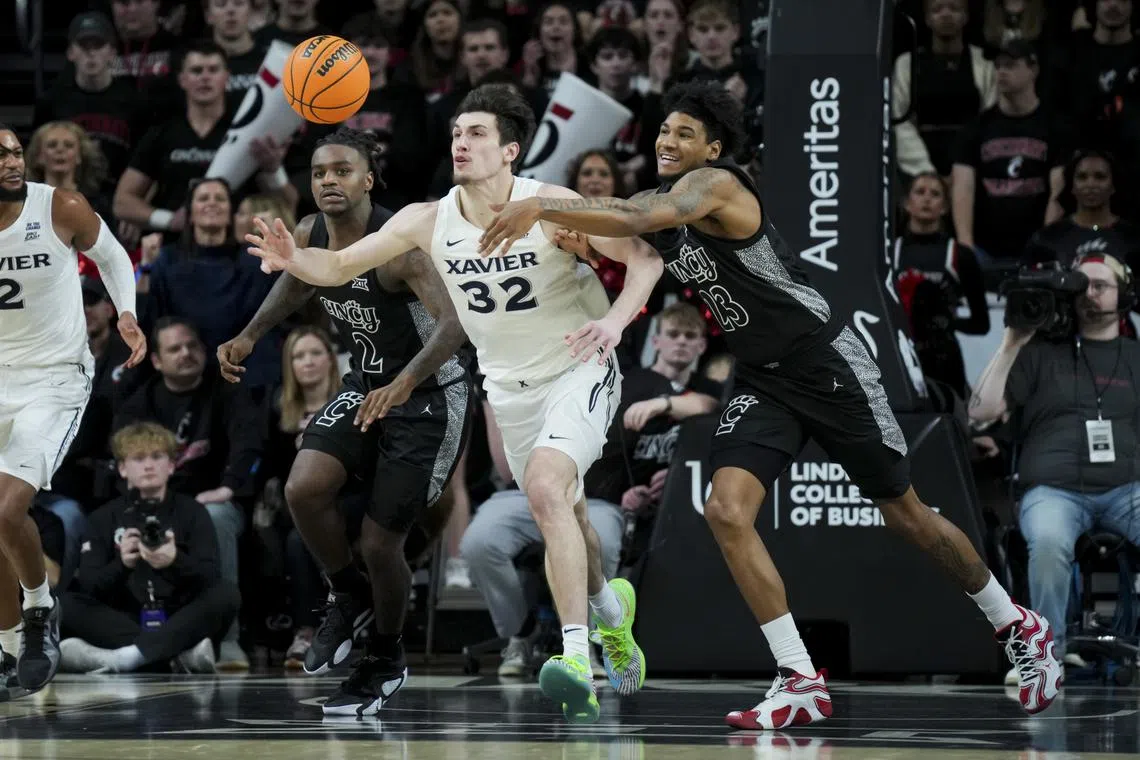 Dec 14, 2024; Cincinnati, Ohio, USA; Xavier Musketeers forward Zach Freemantle (32) battles for the loose ball against Cincinnati Bearcats forward Dillon Mitchell (23) in the second half at Fifth Third Arena. Aaron Doster-Imagn Images/File Photo