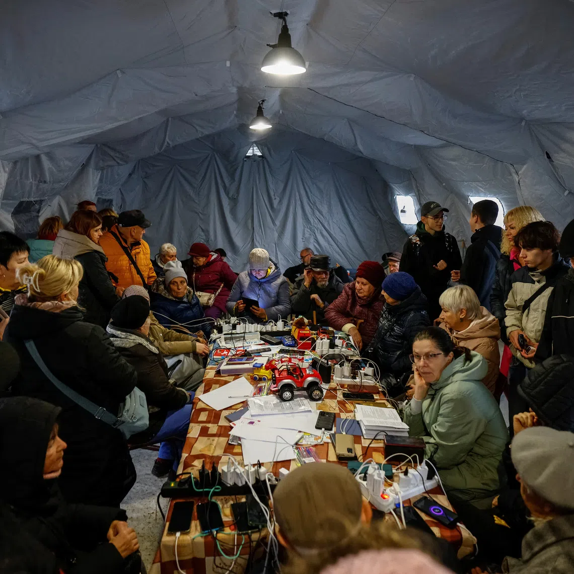 People shelter inside an invincibility centre, where they can use Internet connection, charge their devices and warm up, amid water and electricity supply outage, after critical infrastructure was hit during Russian drone attack, in Chernihiv, Ukraine October 21, 2025. REUTERS/Maksym Kishka