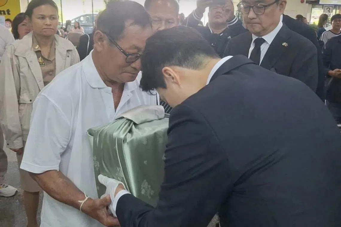 Relatives of Jeju Air crash victim Jongluk Duangmanee receiving her ashes from airport officials at Udon Thani International Airport.