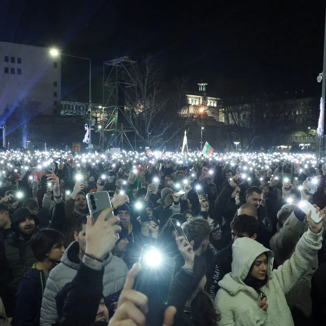 People use the torches on their phones as they demonstrate outside the parliament during an anti-government rally, in Sofia, Bulgaria, December 10, 2025. REUTERS/Stoyan Nenov