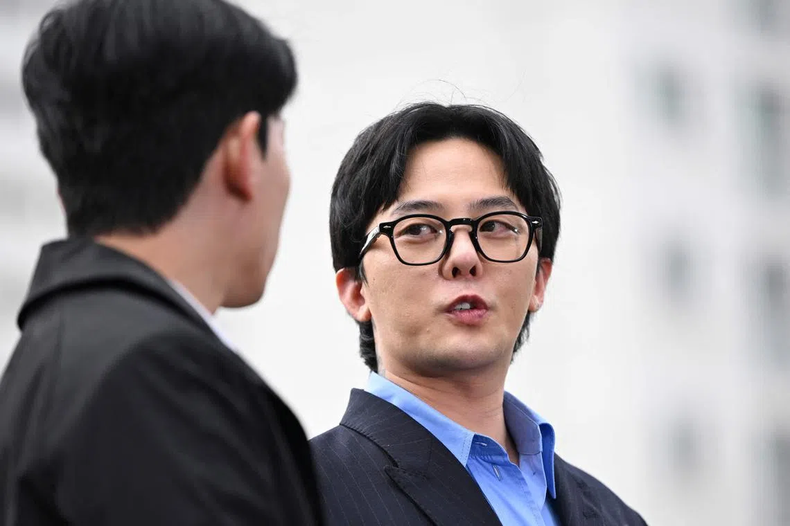 K-pop star G-Dragon (right) speaks to the media as he arrives at a police station for his police questioning in Incheon on November 6, 2023. 