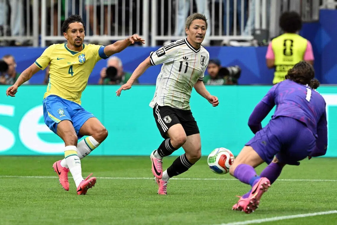Japan's forward #11 Daizen Maeda (C) runs towards Brazil's goalkeeper #01 Alisson (R) as Brazil's defender #04 Marquinhos (L) looks on during the 2026 World Cup round of 32 football match between Brazil and Japan at the Houston Stadium in Houston on June 29, 2026.  (Photo by RONALDO SCHEMIDT / AFP)