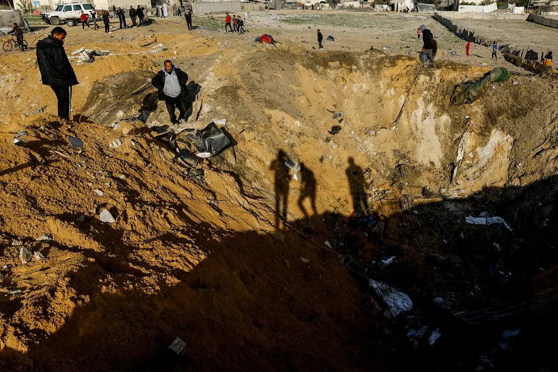 File photo: Palestinians gather near a crater at the site of an Israeli strike on a house, amid the ongoing conflict between Israel and Palestinian Islamist group Hamas, in Rafah, in the southern Gaza Strip, February 18, 2024. REUTERS/Mohammed Salem/File photo