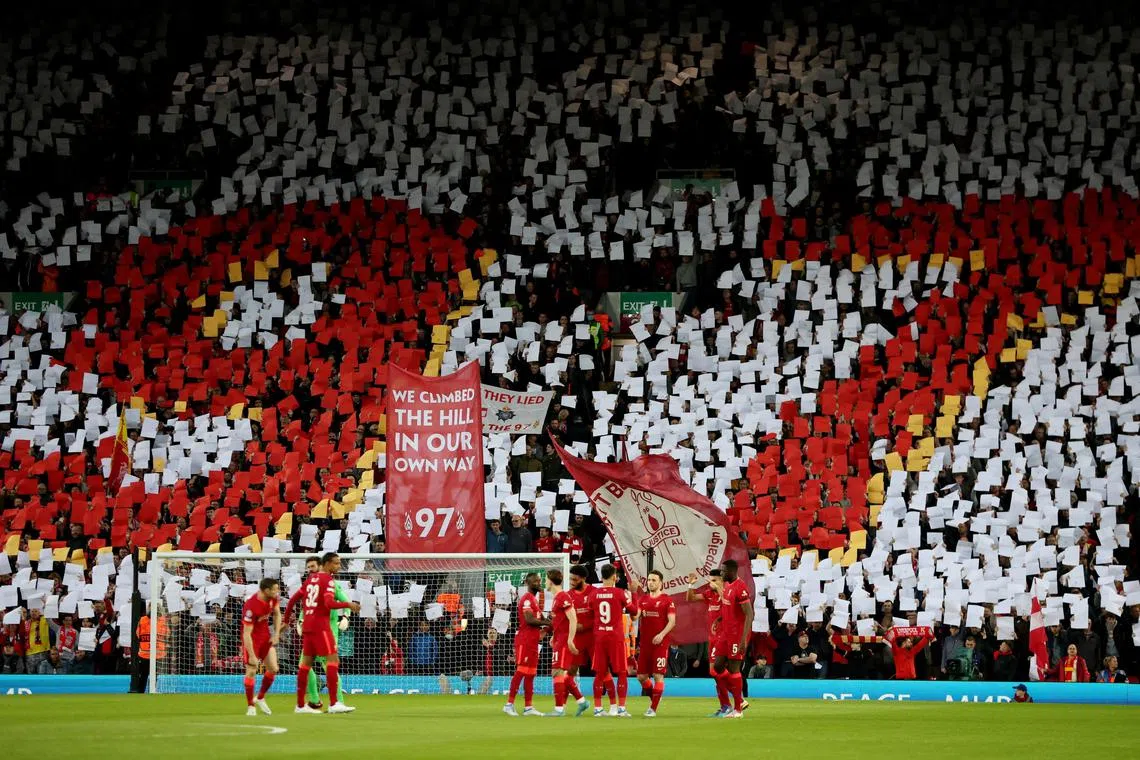 Liverpool fans hold signs for the 97 Hillsborough disaster victims inside the Anfield stadium before a match, on April 13, 2022.