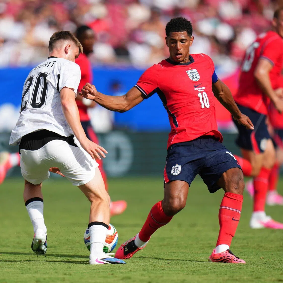 England's Jude Bellingham (right) tackles Callum McCowatt of New Zealand during the international friendly match between England and New Zealand at Raymond James Stadium on June 06 in Tampa, Florida.   