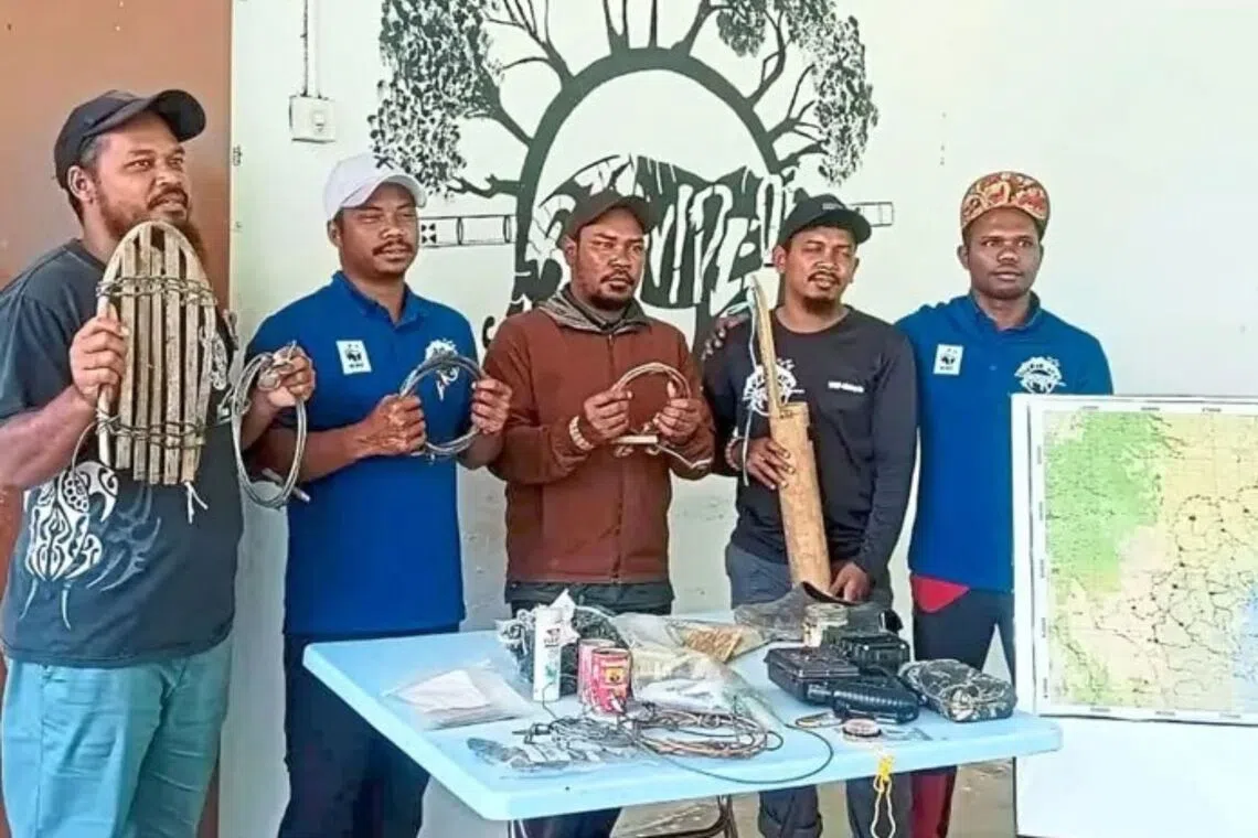 Mr Yahya Charol (second from right) and a team of rangers showing snares and traps used by poachers to catch wildlife.
