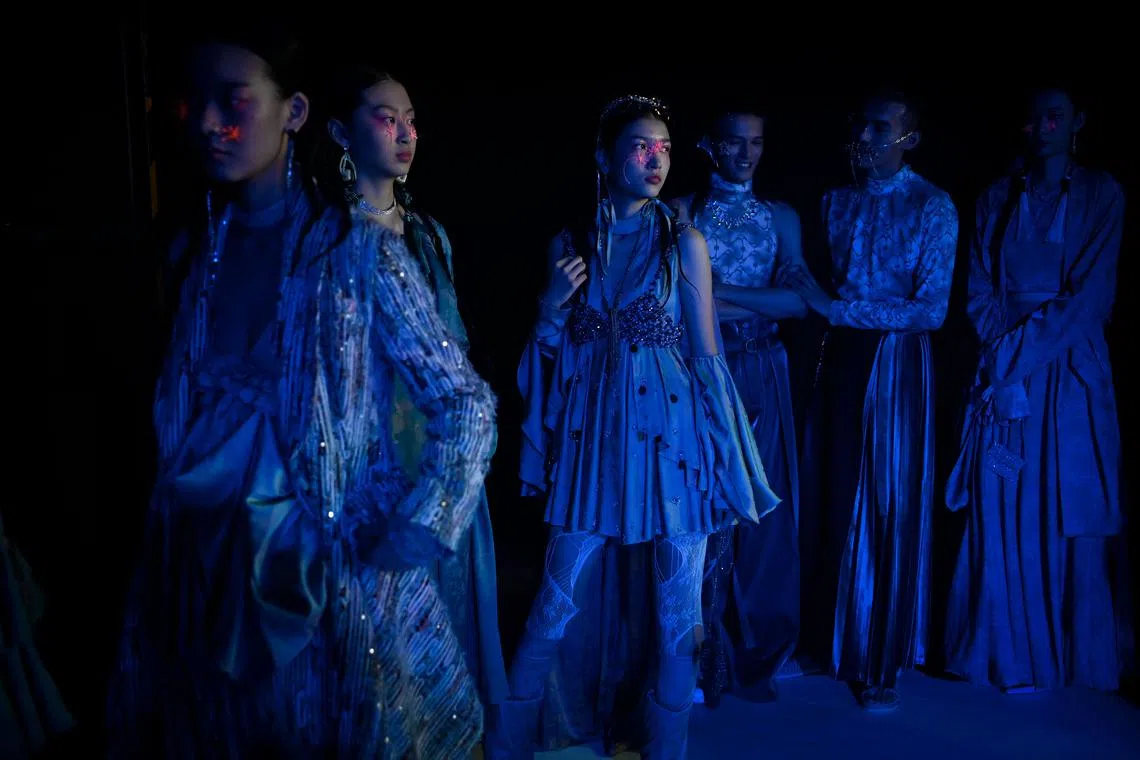 Models preparing backstage before displaying creations from Moe Ho by He Mengmeng on Sept 8.