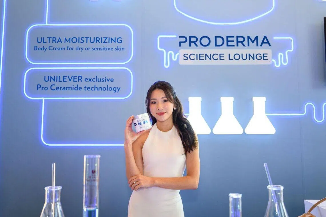 Singapore content creator Mongabong holding a tub of Vaseline Pro Derma Ultra Moisturising Body Cream