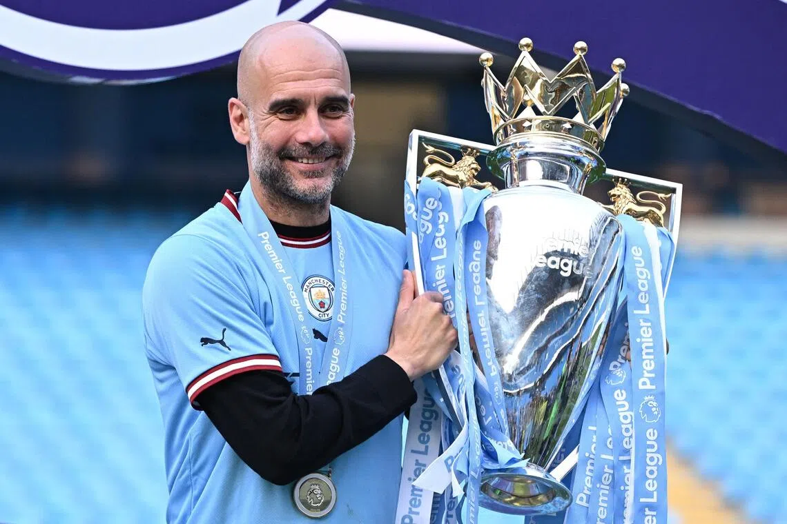 Former Manchester City manager Pep Guardiola poses with the Premier League trophy in 2023.