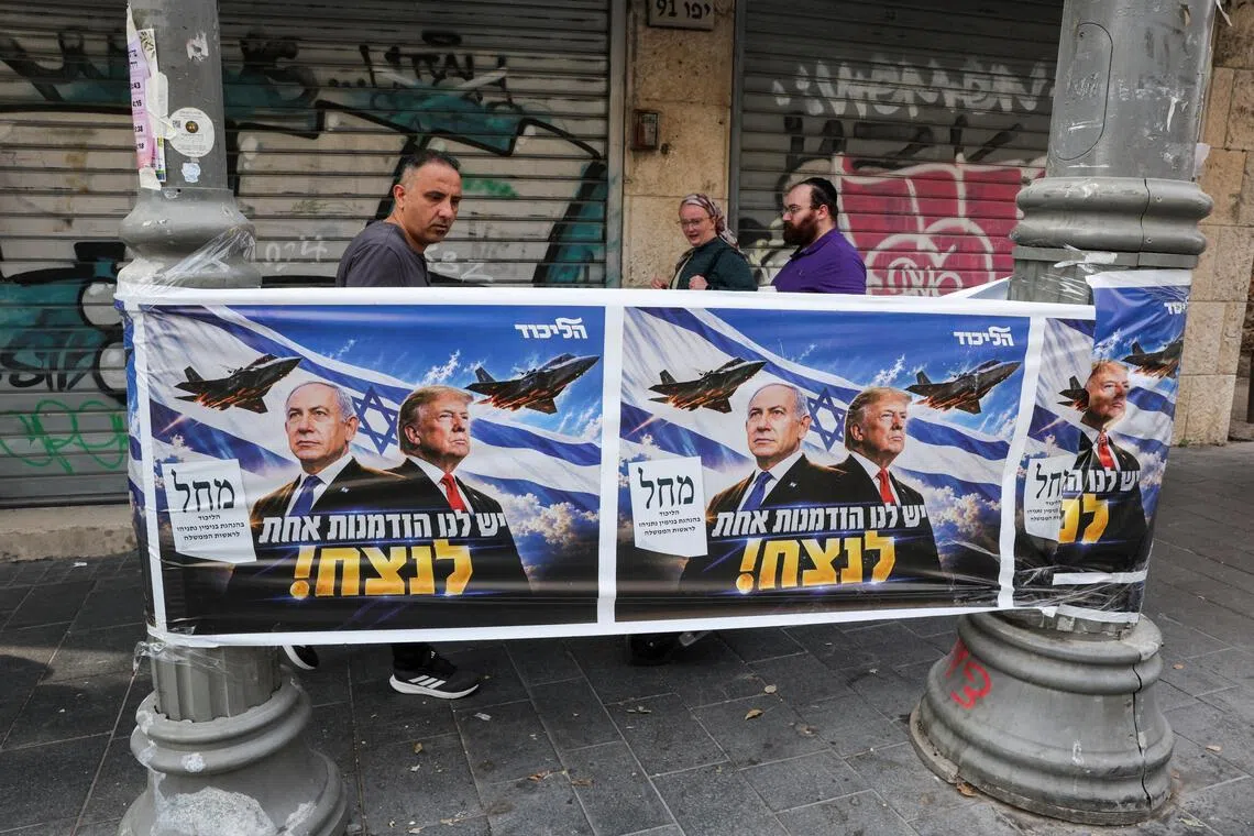 People walk past a poster of Israeli Prime Minister and Likud party leader Benjamin Netanyahu and US President Donald Trump during the country's national elections in central Jerusalem, October 27, 2026. REUTERS/Kevin Coombs

     TPX IMAGES OF THE DAY