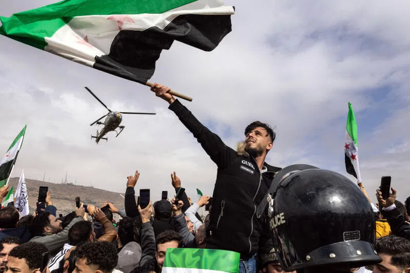 Syrians gather for a military parade in Damascus, on Dec 8.
