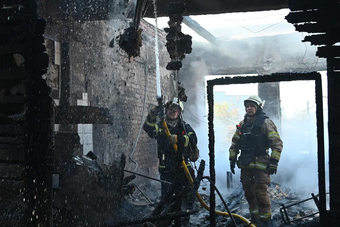 Ukrainian rescuers working to extinguish a fire at a sewing factory in Ukraine's Kharkiv, following a Russian missile attack on April 18.