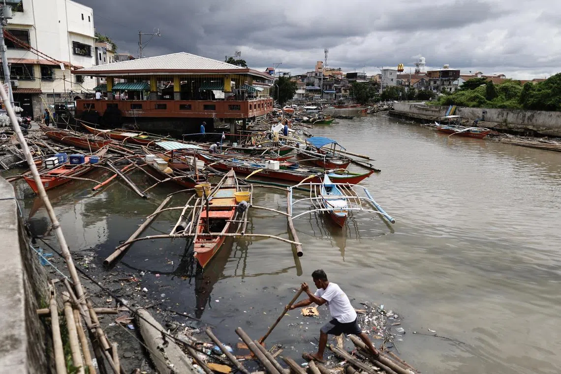 A Philippine fisherman securing a makeshift raft on Sept 13 in anticipation of monsoonal rains and tropical storm Bebinca's impact in Bacoor city, about 30km south-east of Manila. Bebinca is now approaching the coast of China.