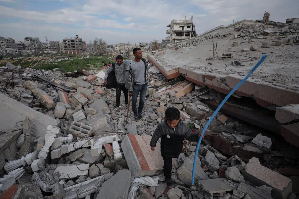 Ismael Mohammed and his children, who were displaced to the southern part of Gaza at Israel's order during the war, arrive at their destroyed house after returning amid a ceasefire between Israel and Hamas, in Jabalia, northern Gaza Strip on Jan 28.