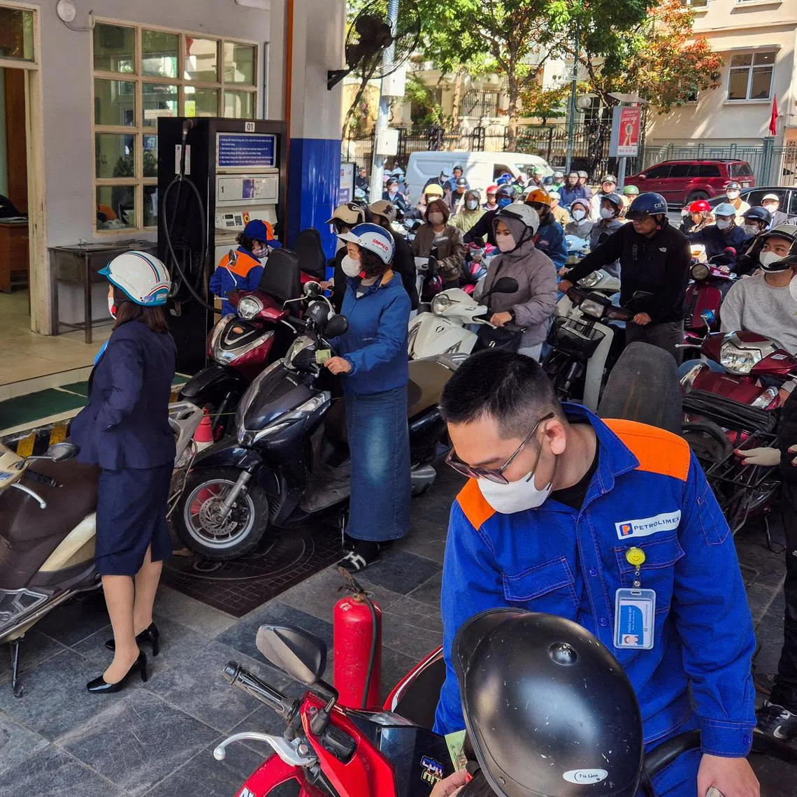 People queue at a petrol station in Hanoi on March 10. Vietnam has temporarily waived an environmental tax on fuel to cut soaring petrol prices.