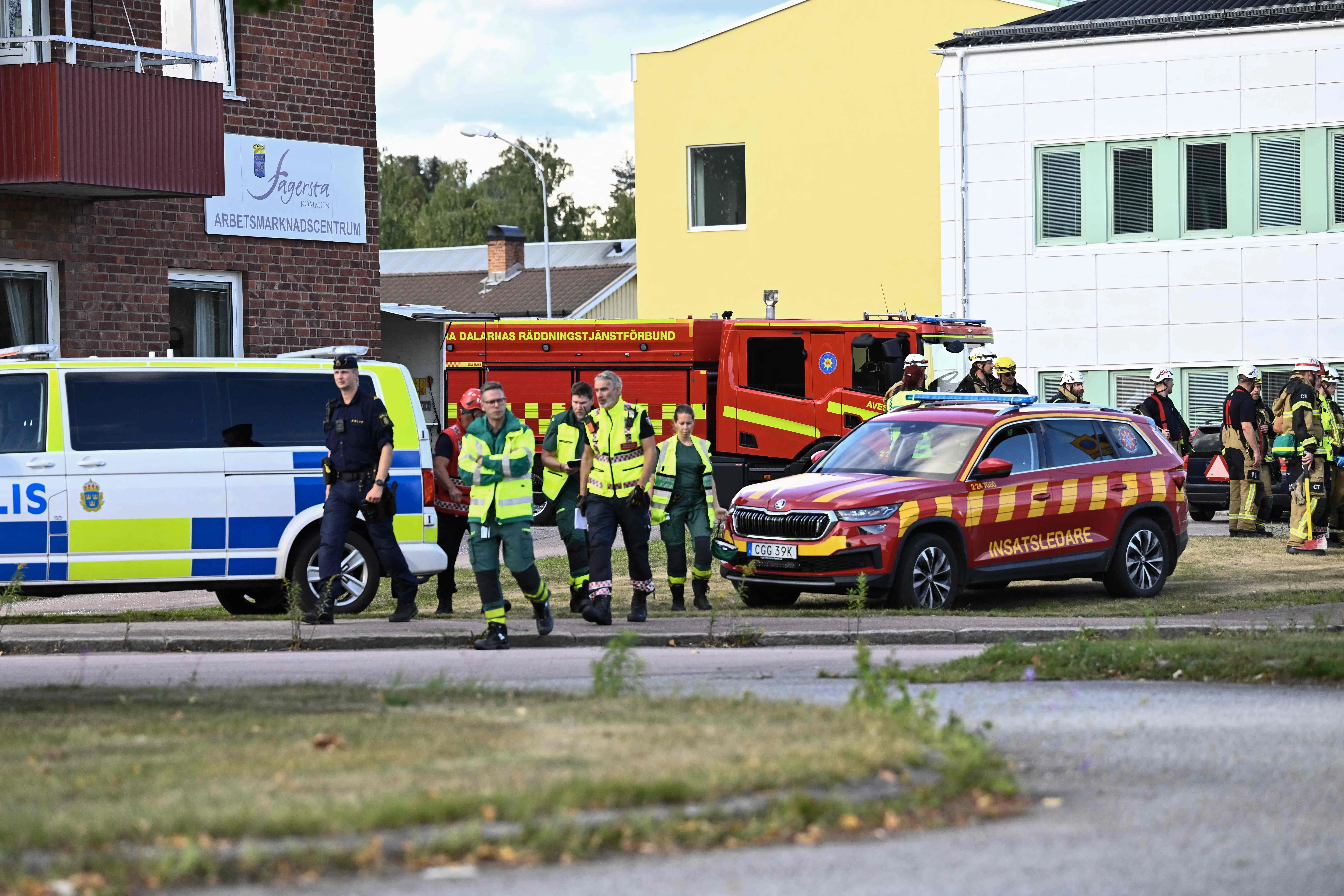 Police officers and rescue services work at the scene where an attacker with a sword wounded several people at a high school in Fagersta, central Sweden on August 21, 2026. At least three were wounded after an attacker with a sword entered a high school in central Sweden, authorities said, while media reported the perpetrator had been shot by police. "An assailant armed with a sword has entered Brinellskolan and wounded several people," the Fagersta municipality said in a statement, adding the assailant had been detained by police. Aftonbladet newspaper reported that a person wielding a machete had been shot by police. (Photo by Fredrik SANDBERG / TT NEWS AGENCY / AFP) / Sweden OUT