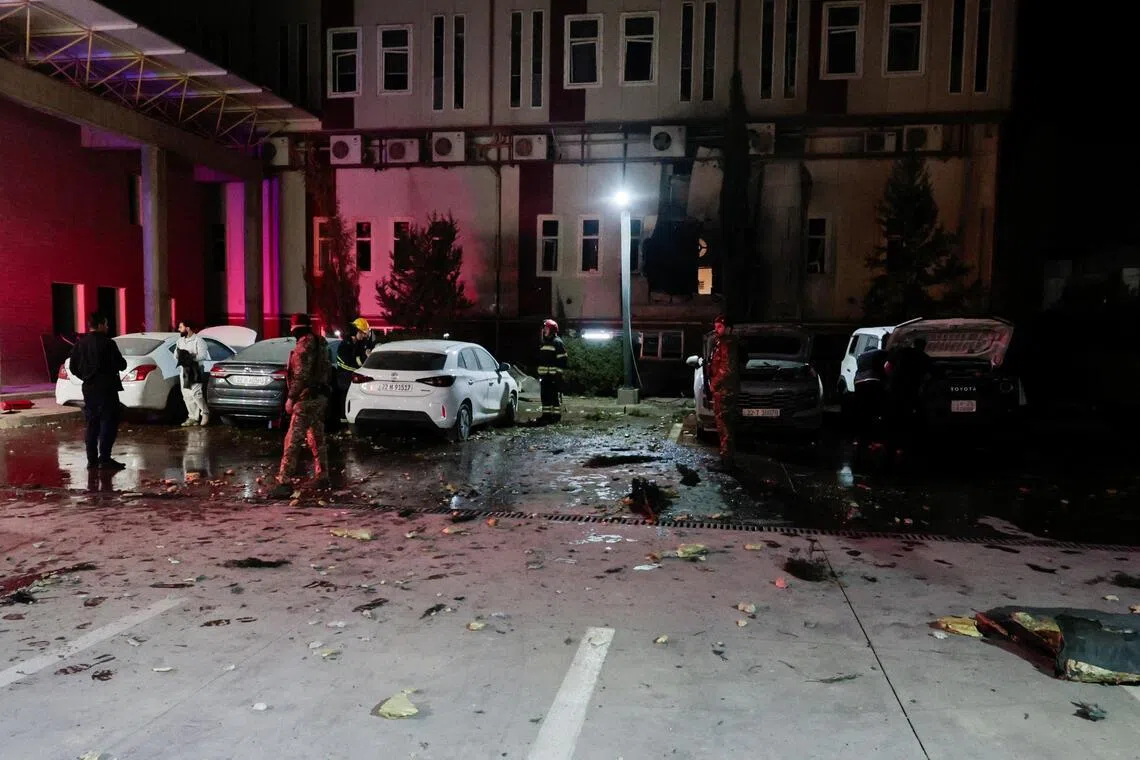 People gather near debris from a drone that fell onto a building near Erbil airport, amid the US-Israeli conflict with Iran, in the Ankawa district of Erbil, Iraq, on March 4, 2026. 