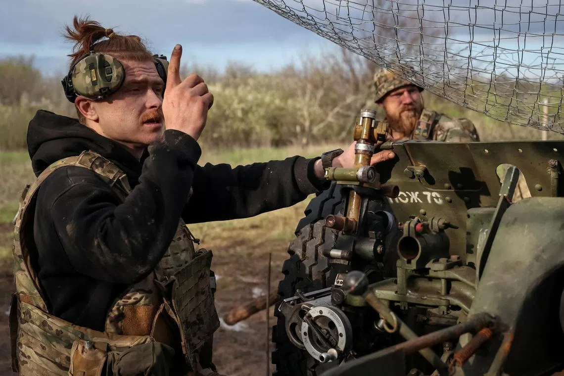 Ukrainian servicemen prepare to fire a howitzer at a front-line position in Bakhmut.