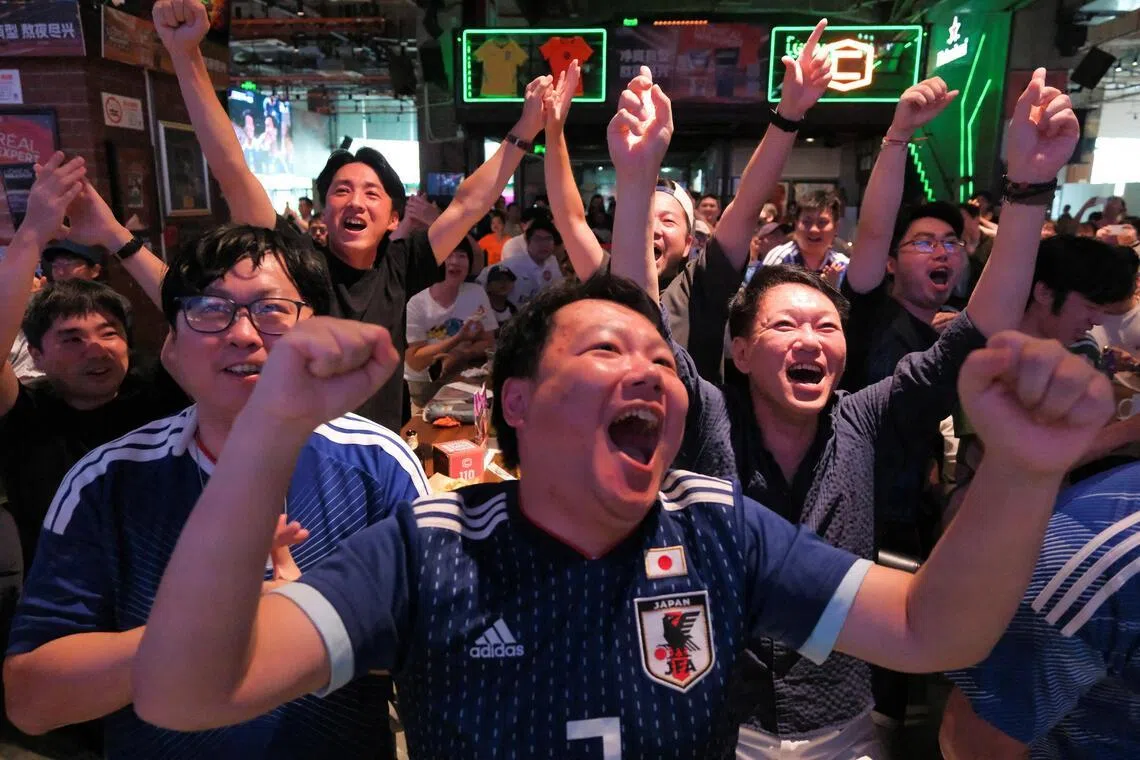 Football fans react during a FIFA World Cup match between Japan and Tunisia at a football watch party in Shanghai on June 21.