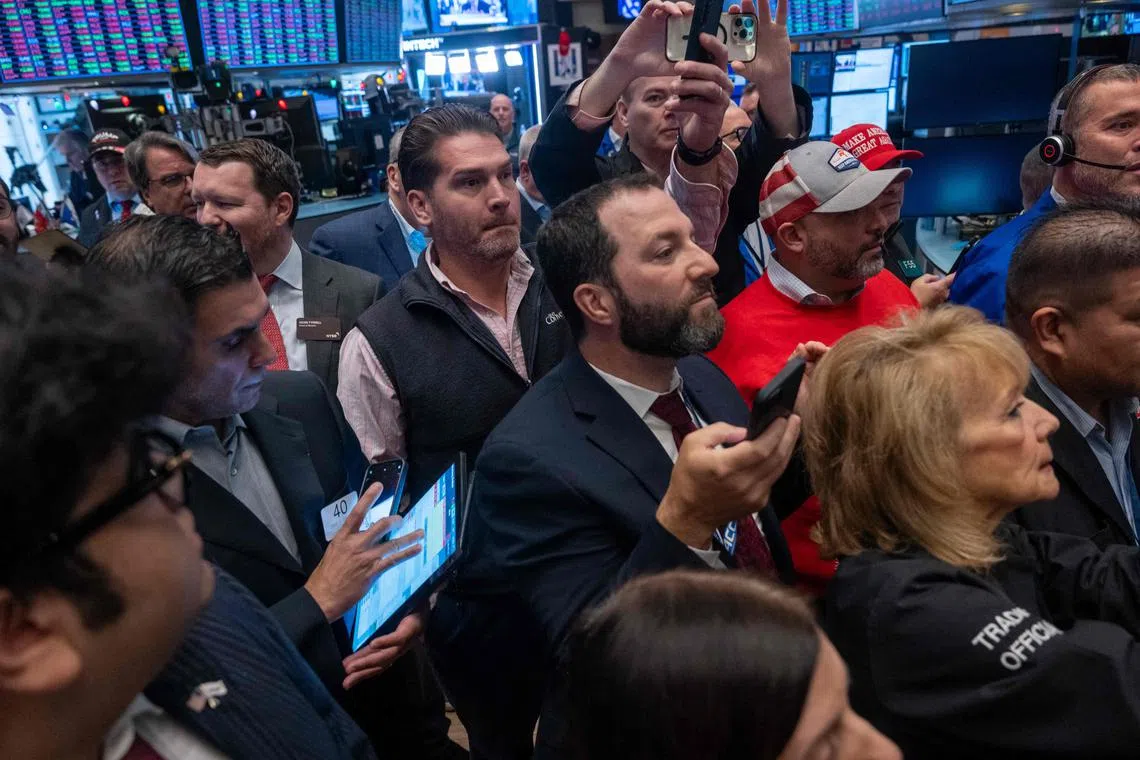 Traders watching as US President-elect Donald Trump walks onto the floor of the New York Stock Exchange with his wife, Melania, on Dec 12.
