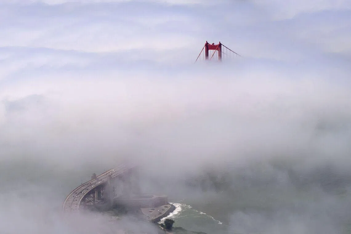 TOPSHOT - In this aerial view, fog rolls by the Golden Gate Bridge in San Francisco, California on May 20, 2026. (Photo by JOSH EDELSON / AFP)