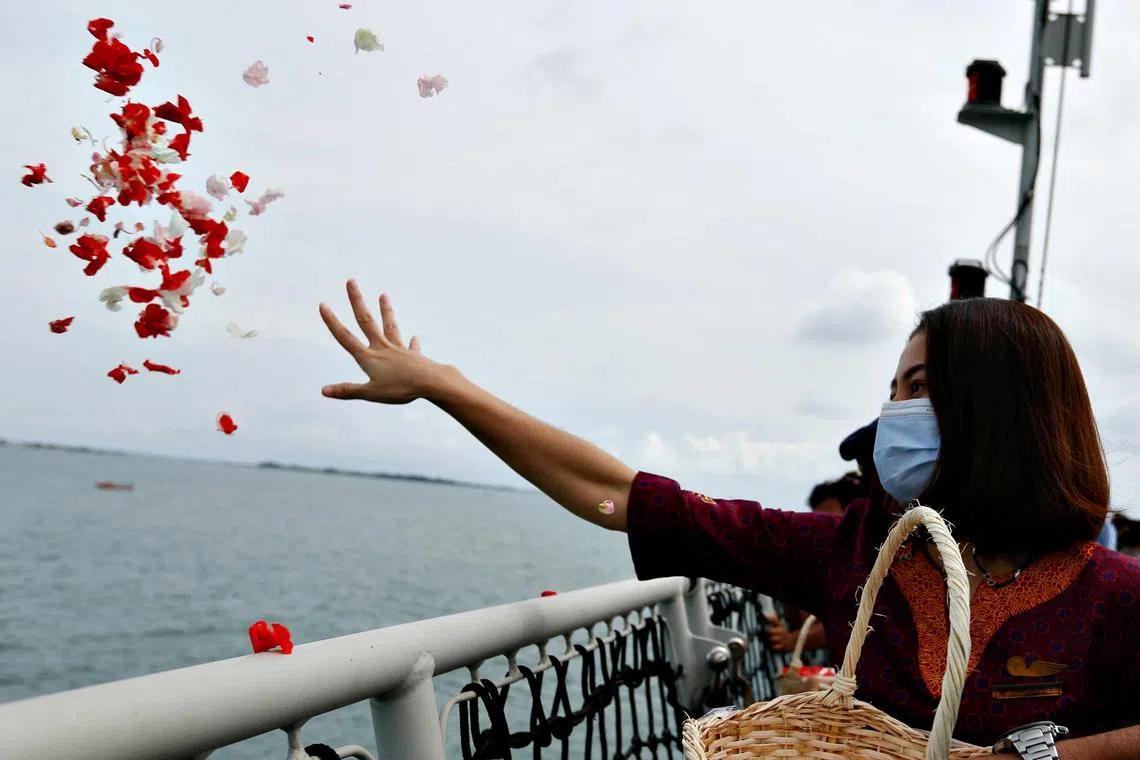 A colleague of the crew of Sriwijaya Air flight SJ 182 throws flower petals as they visit the site of the crash on Jan 22, 2021.