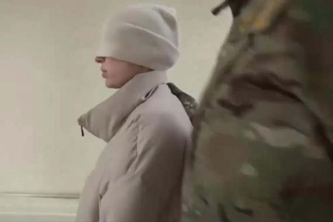 Russian state news agency RIA Novosti posted an FSB video showing officers handcuffing and escorting a woman in a white coat with a white hat pulled down over her eyes.