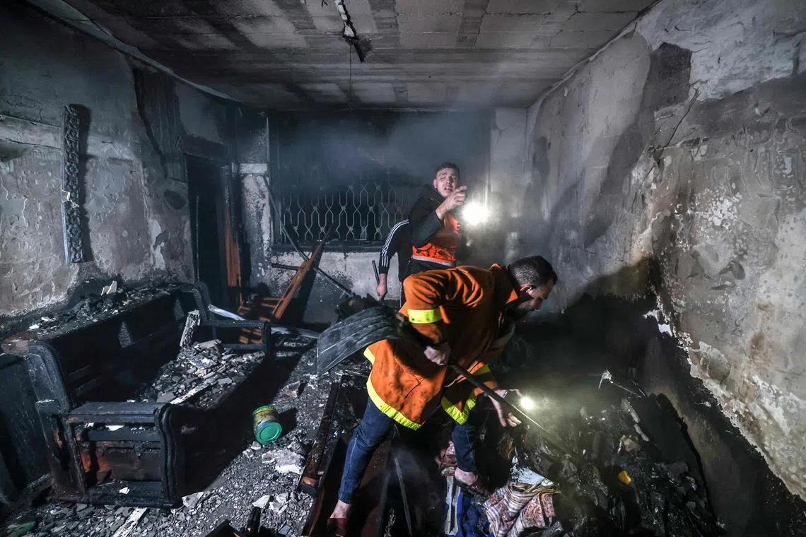 Palestinian firefighters extinguish flames in an apartment ravaged by fire in the Jabalia refugee camp in the northern Gaza strip, in Palestine, on Nov 17, 2022.