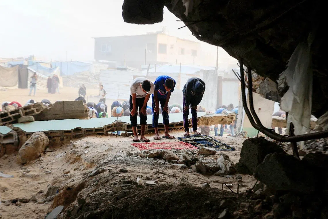 Palestinian boys perform Eid al-Adha prayers inside the ruins of the destroyed Al-Albani Mosque in Khan Younis.
