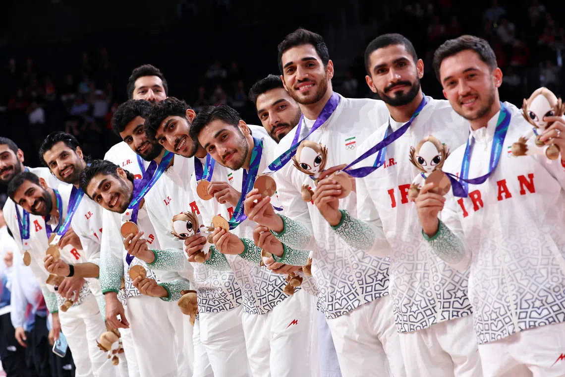 Iran’s team celebrate on the podium during the victory ceremony.