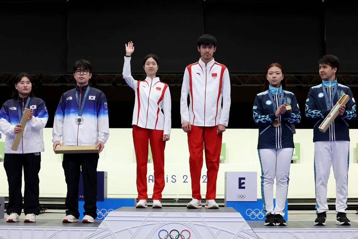 China's Huang Yuting and Sheng Lihao standing on the top of the podium after winning the 10m air rifle mixed-team event at the Paris Olympics.